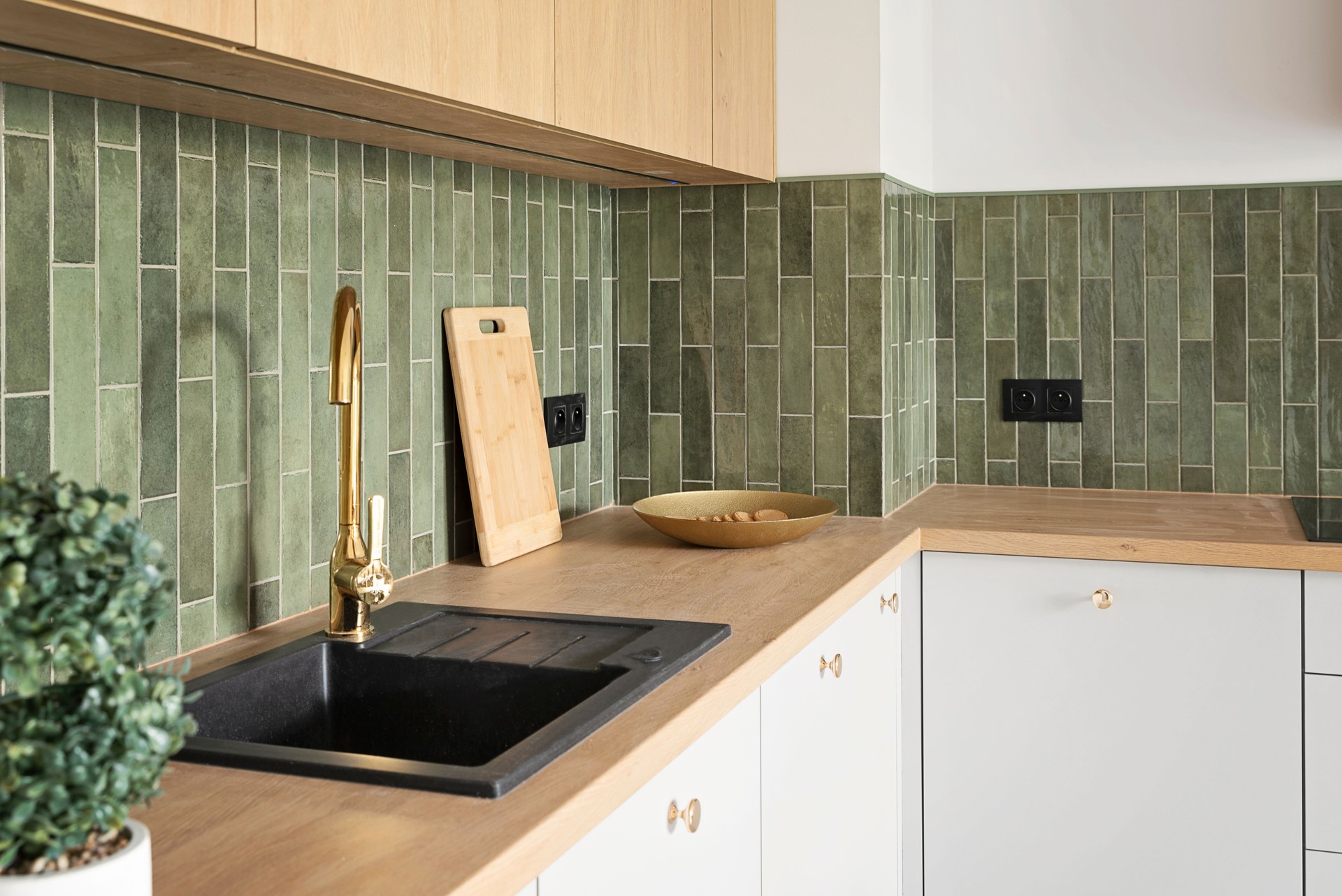 Modern interior of kitchen with beige furniture, wooden kitchen worktop and kitchen sink with water tap. New design in apartment. Indoors architecture. Real estate.
